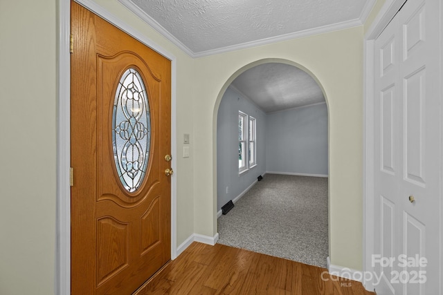 7011 S Providence Rd, Waxhaw, NC 28173 - entryway with arched walkways, dark wood-type flooring, ornamental molding, and a textured ceiling