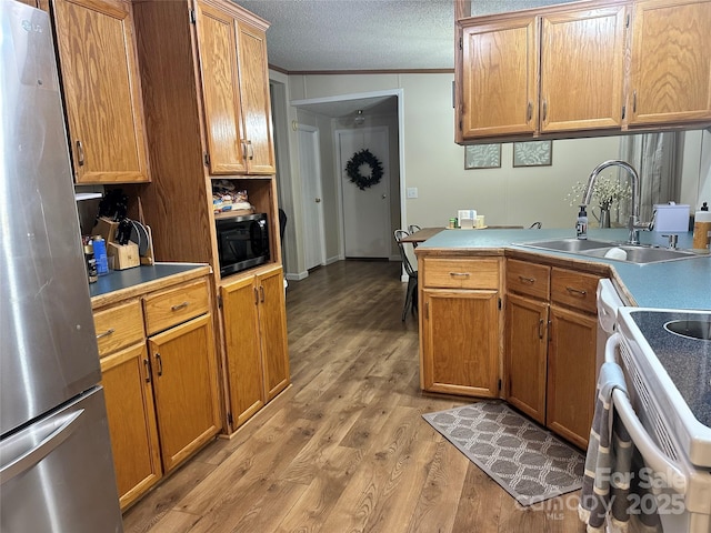 117 Haystack Ln, Olin, NC 28660 - kitchen featuring freestanding refrigerator, light wood-type flooring, crown molding, electric range, and brown cabinets