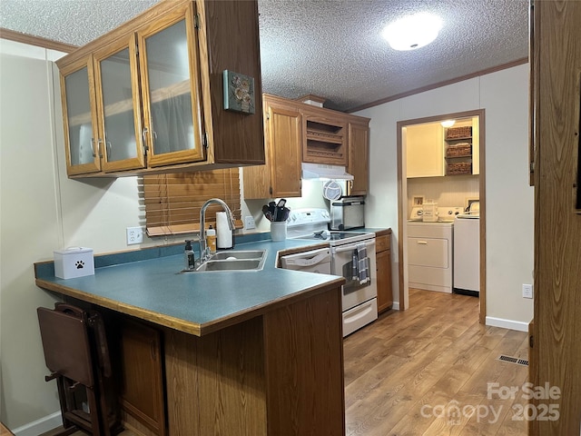 117 Haystack Ln, Olin, NC 28660 - kitchen featuring washer and dryer, white electric range, a textured ceiling, under cabinet range hood, and a peninsula