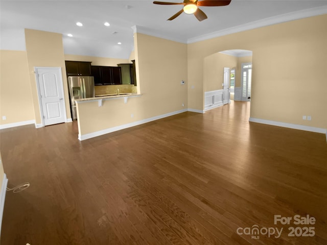13419 Morgan Lee Ave, Charlotte, NC 28213 - unfurnished living room featuring a ceiling fan, arched walkways, crown molding, dark wood-type flooring, and recessed lighting