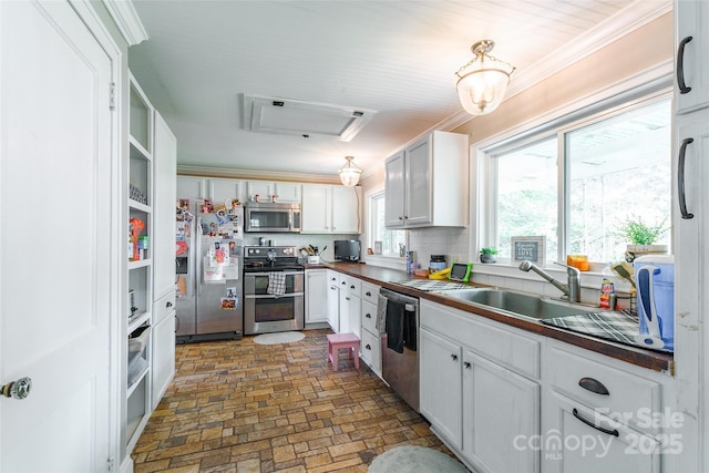 904 Venus St, Kannapolis, NC 28083 - kitchen with stainless steel appliances, white cabinetry, brick patterned flooring, dark countertops, and crown molding