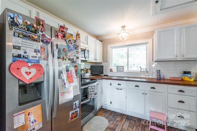 904 Venus St, Kannapolis, NC 28083 - kitchen with appliances with stainless steel finishes, brick patterned floors, tasteful backsplash, crown molding, and white cabinetry