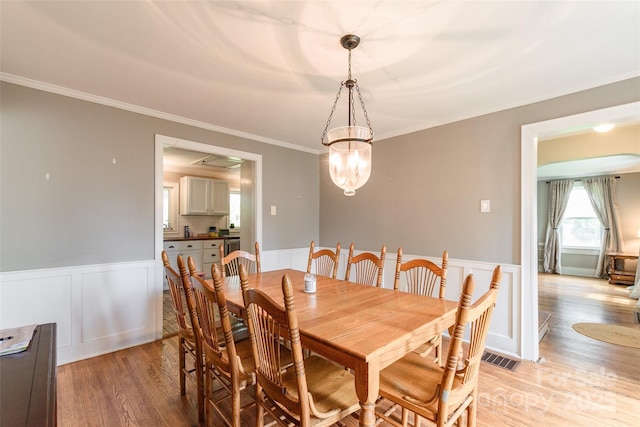 904 Venus St, Kannapolis, NC 28083 - dining room with light wood-style floors, wainscoting, ornamental molding, a decorative wall, and a chandelier
