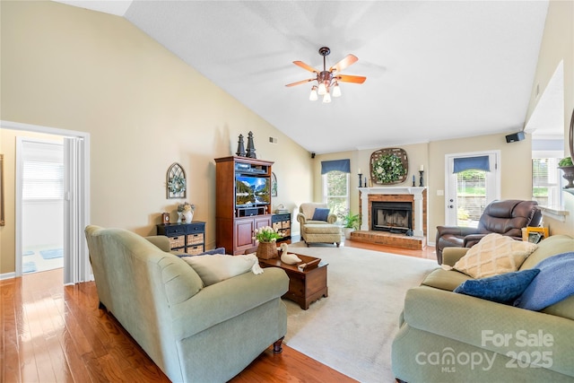 4313 Wynborough Ln, Charlotte, NC 28269 - living room featuring ceiling fan, wood finished floors, a brick fireplace, plenty of natural light, and high vaulted ceiling