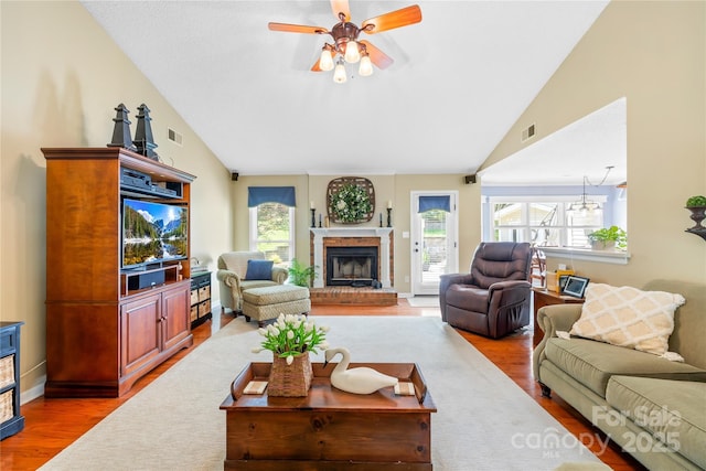 4313 Wynborough Ln, Charlotte, NC 28269 - living area featuring vaulted ceiling, wood finished floors, a brick fireplace, and a ceiling fan