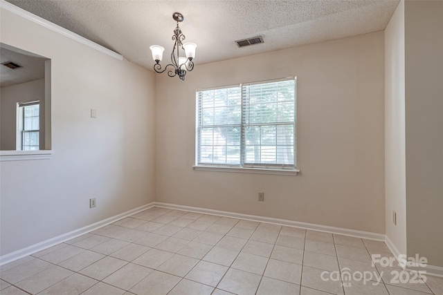 1801 Teddington Dr, Charlotte, NC 28214 - spare room with a textured ceiling, light tile patterned floors, and a chandelier