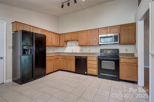 1801 Teddington Dr, Charlotte, NC 28214 - kitchen with black appliances, track lighting, light tile patterned floors, a towering ceiling, and light countertops