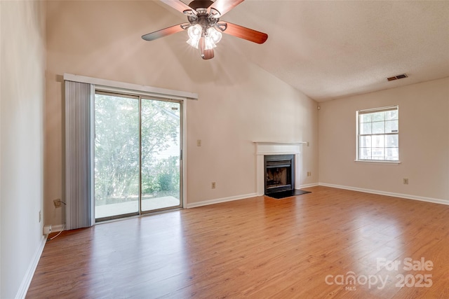 1801 Teddington Dr, Charlotte, NC 28214 - unfurnished living room with lofted ceiling, a fireplace with flush hearth, wood finished floors, and a ceiling fan