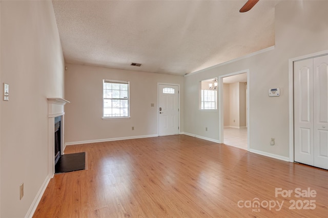 1801 Teddington Dr, Charlotte, NC 28214 - unfurnished living room with a chandelier, plenty of natural light, a ceiling fan, a fireplace, and a textured ceiling