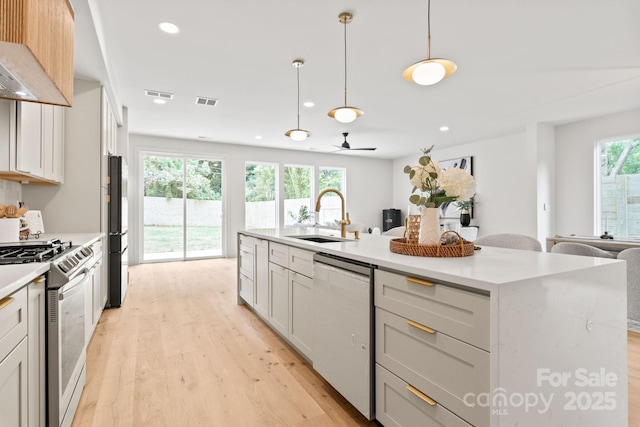 2733 Cowles Rd, Charlotte, NC 28208 - kitchen with stainless steel gas stove, dishwashing machine, open floor plan, extractor fan, and light wood finished floors