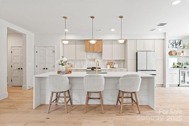 2733 Cowles Rd, Charlotte, NC 28208 - kitchen with beverage cooler, freestanding refrigerator, backsplash, light countertops, and a spacious island