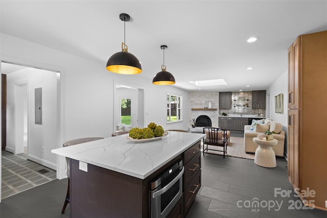 3701 Table Rock Rd, Charlotte, NC 28226 - kitchen with open floor plan, a large fireplace, electric panel, a breakfast bar, and a skylight