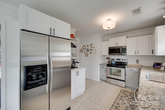 11615 Chadburn Ln, Charlotte, NC 28215 - kitchen featuring appliances with stainless steel finishes, open shelves, white cabinetry, light tile patterned flooring, and ornamental molding