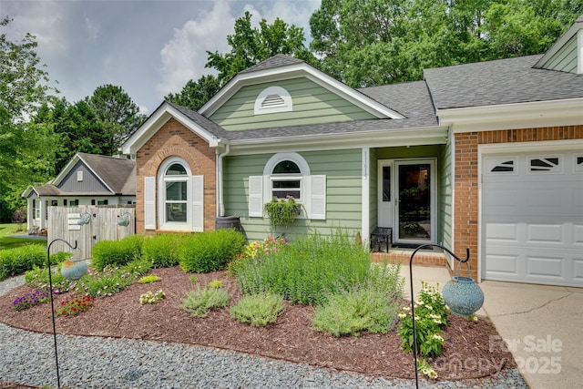 11615 Chadburn Ln, Charlotte, NC 28215 - view of front of home with a shingled roof, a garage, and brick siding