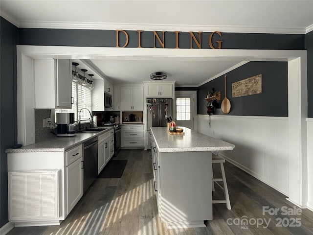 1314 Hathcock Ave, Albemarle, NC 28001 - kitchen with stainless steel appliances, dark wood-style flooring, a kitchen island, wainscoting, and ornamental molding
