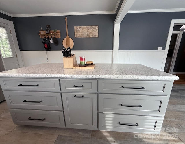 1314 Hathcock Ave, Albemarle, NC 28001 - kitchen featuring light stone counters, wainscoting, gray cabinets, and crown molding