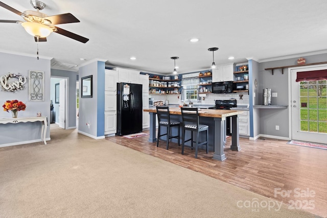 32 Bishop Ln, Flat Rock, NC 28731 - kitchen with open shelves, black appliances, crown molding, white cabinets, and plenty of natural light