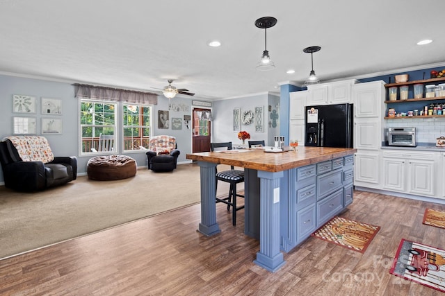 32 Bishop Ln, Flat Rock, NC 28731 - kitchen featuring butcher block countertops, black fridge, white cabinetry, crown molding, and open floor plan
