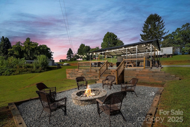 32 Bishop Ln, Flat Rock, NC 28731 - patio terrace at dusk with an outdoor fire pit, a lawn, and stairway