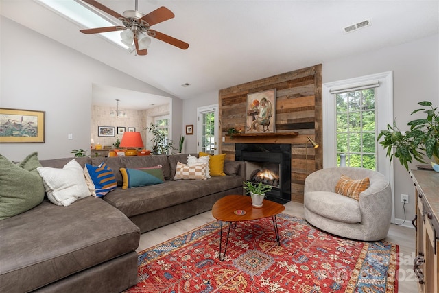 330 Stonehollow Rd, Fletcher, NC 28732 - living area featuring a fireplace, a ceiling fan, vaulted ceiling, wood finished floors, and a chandelier