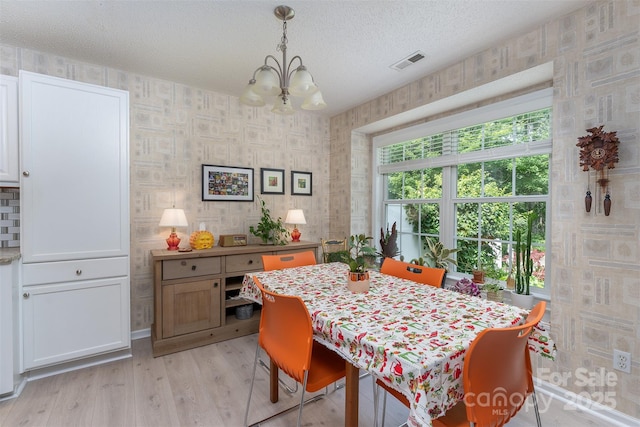 330 Stonehollow Rd, Fletcher, NC 28732 - dining room featuring a chandelier, light wood finished floors, a textured ceiling, and wallpapered walls