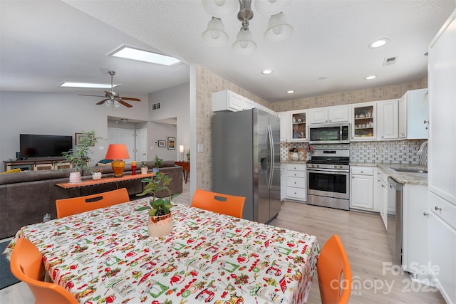 330 Stonehollow Rd, Fletcher, NC 28732 - kitchen with stainless steel appliances, white cabinets, light wood-type flooring, glass insert cabinets, and lofted ceiling