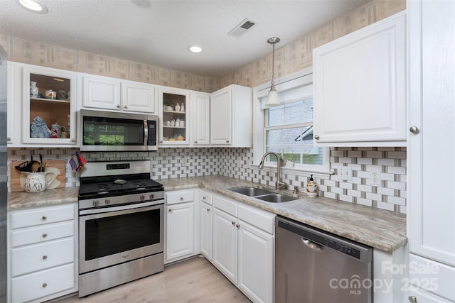 330 Stonehollow Rd, Fletcher, NC 28732 - kitchen with stainless steel appliances, decorative backsplash, white cabinets, glass insert cabinets, and a textured ceiling