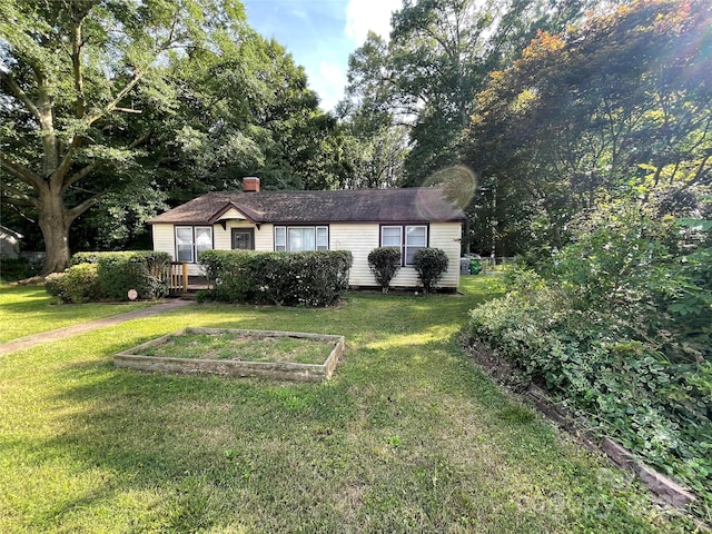 2411 Rebecca Ave, Charlotte, NC 28208 - view of front of property featuring a front lawn, a chimney, and a garden