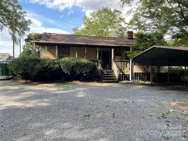 2411 Rebecca Ave, Charlotte, NC 28208 - view of front of home with a chimney, a detached carport, covered porch, and driveway
