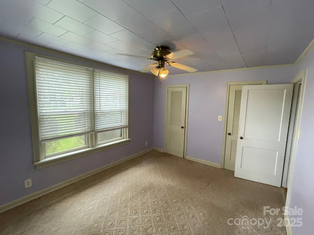 2411 Rebecca Ave, Charlotte, NC 28208 - unfurnished bedroom with two closets, carpet flooring, and a ceiling fan