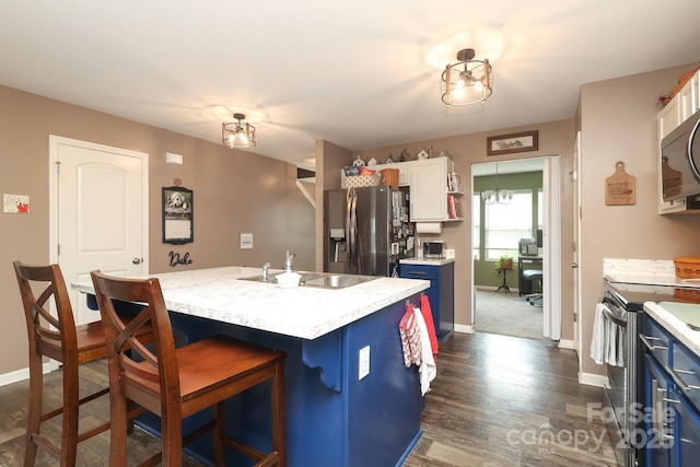 903 Von Buren Blvd, Rock Hill, SC 29730 - kitchen with stainless steel appliances, blue cabinetry, light countertops, a breakfast bar area, and dark wood-type flooring