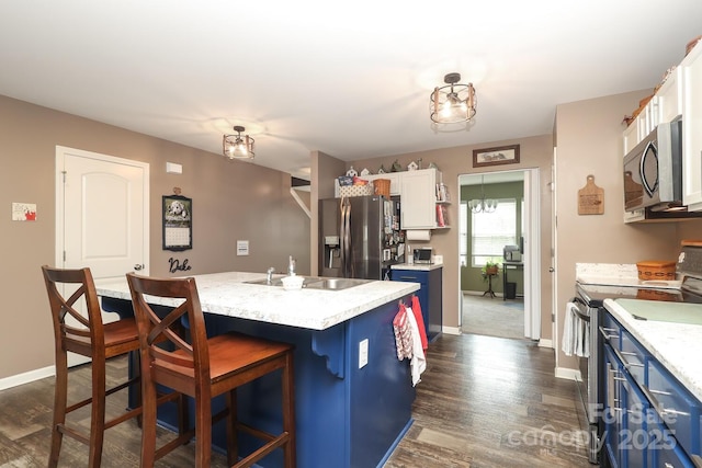 903 Von Buren Blvd, Rock Hill, SC 29730 - kitchen with appliances with stainless steel finishes, blue cabinets, a breakfast bar, a kitchen island, and dark wood-type flooring