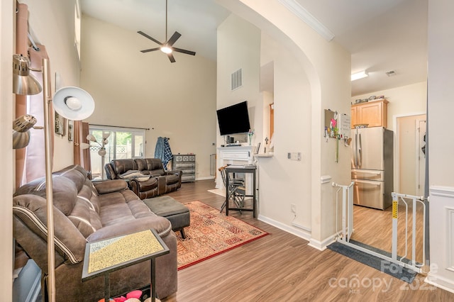 4703 David Cox Rd, Charlotte, NC 28269 - living area featuring arched walkways, wood finished floors, ceiling fan, and a high ceiling