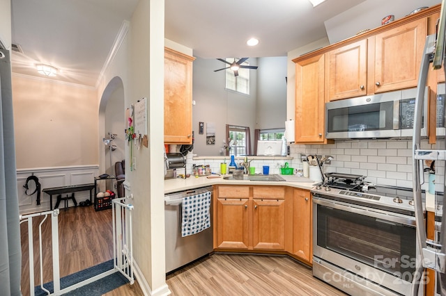 4703 David Cox Rd, Charlotte, NC 28269 - kitchen with appliances with stainless steel finishes, light wood-type flooring, a ceiling fan, light countertops, and crown molding