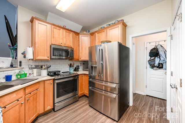 4703 David Cox Rd, Charlotte, NC 28269 - kitchen featuring stainless steel appliances, light wood-style floors, tasteful backsplash, and light countertops