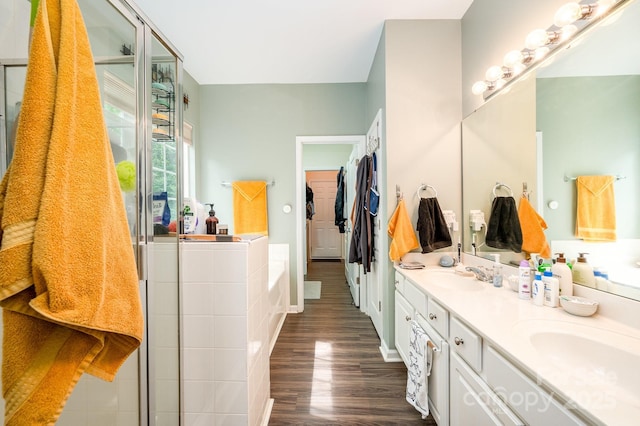 4703 David Cox Rd, Charlotte, NC 28269 - full bathroom with double vanity, wood finished floors, a garden tub, a walk in closet, and a shower with door