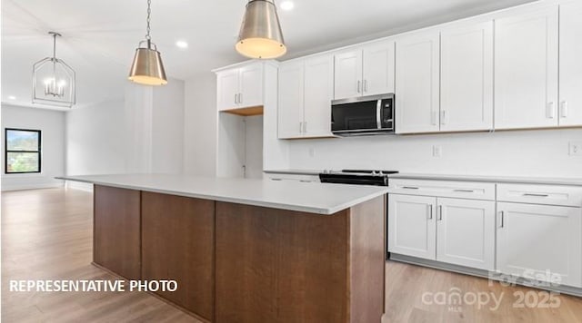 732 Falling Oak Aly Unit 22, Huntersville, NC 28078 - kitchen with stainless steel microwave, light wood-style floors, white cabinets, light countertops, and recessed lighting