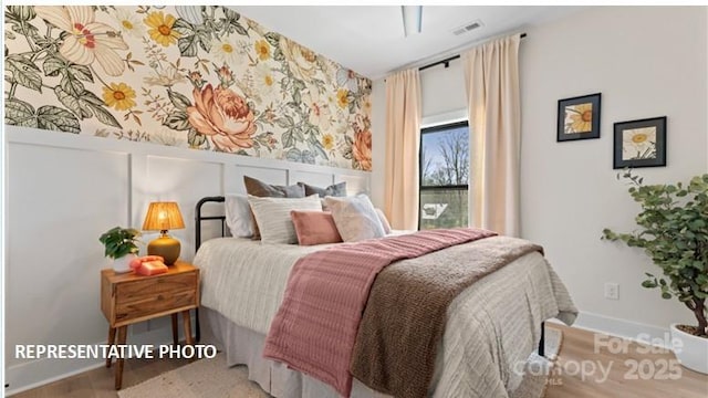 732 Falling Oak Aly Unit 22, Huntersville, NC 28078 - bedroom with wallpapered walls, wood finished floors, and a wainscoted wall