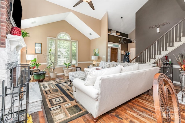 2133 Highland View Ln, Charlotte, NC 28214 - living area featuring ceiling fan, wood finished floors, a fireplace, stairway, and high vaulted ceiling