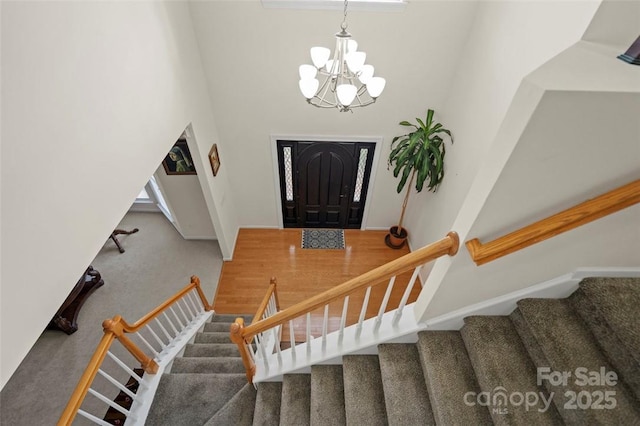 4966 Riverview Dr, Harrisburg, NC 28075 - foyer with carpet flooring, a chandelier, stairway, and a towering ceiling
