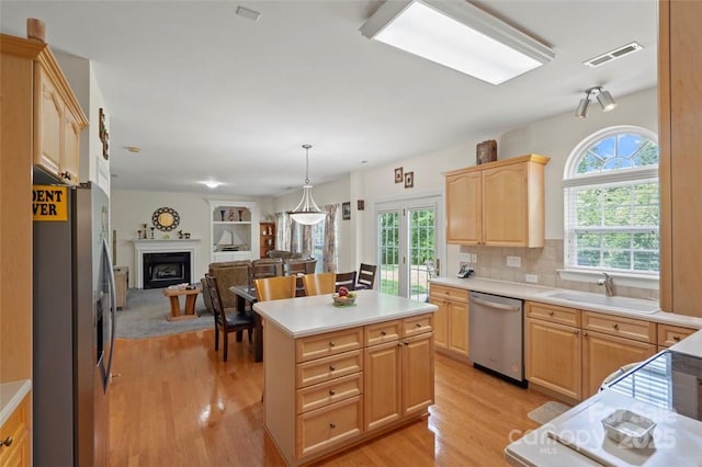 4966 Riverview Dr, Harrisburg, NC 28075 - kitchen with stainless steel appliances, light brown cabinetry, open floor plan, light wood-style floors, and light countertops