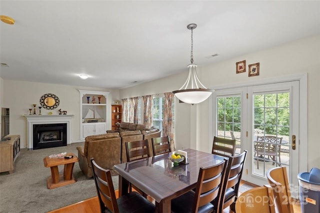4966 Riverview Dr, Harrisburg, NC 28075 - dining area featuring plenty of natural light, a fireplace with flush hearth, and built in shelves