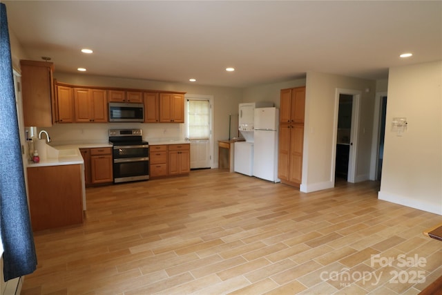 9 Oakland St, Weaverville, NC 28787 - kitchen with appliances with stainless steel finishes, light countertops, light wood-style floors, recessed lighting, and brown cabinetry