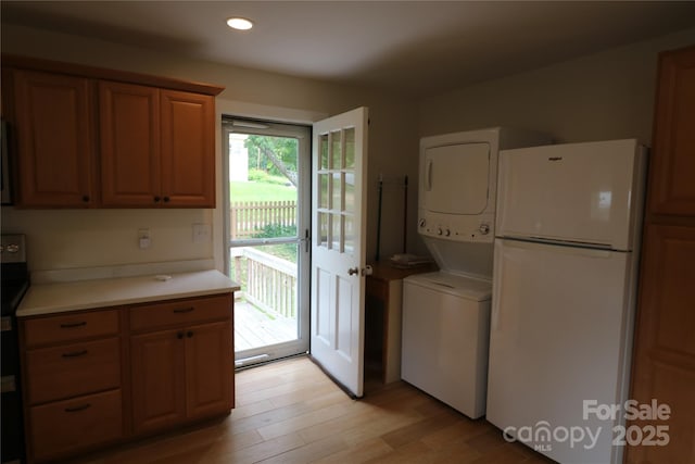 9 Oakland St, Weaverville, NC 28787 - kitchen featuring freestanding refrigerator, stacked washer / dryer, light countertops, light wood-style floors, and recessed lighting
