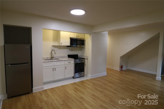 9 Oakland St, Weaverville, NC 28787 - kitchen featuring stainless steel appliances, light wood-type flooring, white cabinets, and open floor plan