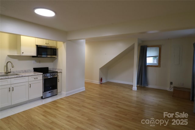 9 Oakland St, Weaverville, NC 28787 - kitchen featuring appliances with stainless steel finishes, light countertops, light wood-style flooring, and white cabinetry