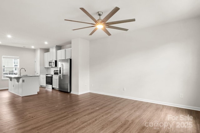 1204 May Apple Dr, Matthews, NC 28104 - kitchen featuring appliances with stainless steel finishes, a breakfast bar area, dark wood-style floors, white cabinetry, and recessed lighting
