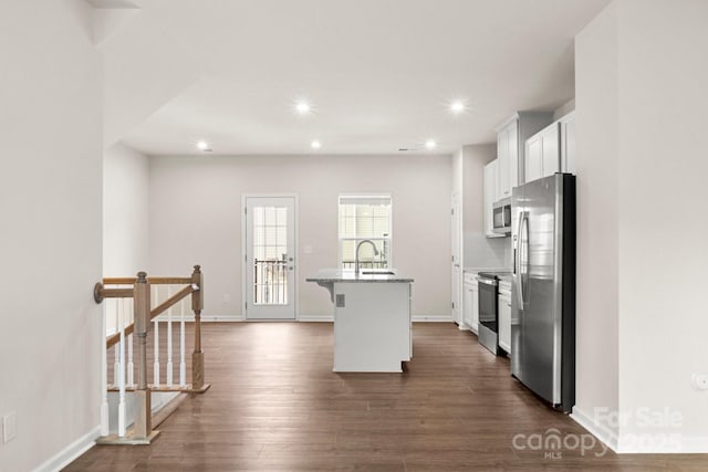 1204 May Apple Dr, Matthews, NC 28104 - kitchen with appliances with stainless steel finishes, a center island with sink, white cabinetry, dark wood finished floors, and recessed lighting