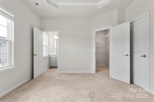 1204 May Apple Dr, Matthews, NC 28104 - unfurnished bedroom with light carpet, crown molding, a walk in closet, a tray ceiling, and a closet