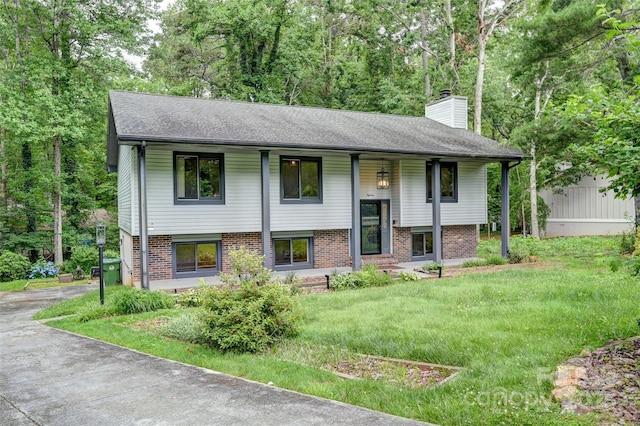 18 Golden Oaks Ln, Fletcher, NC 28732 - split foyer home with a chimney, brick siding, covered porch, a shingled roof, and driveway